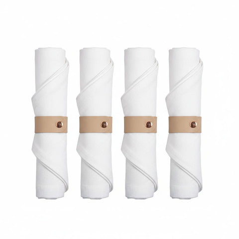 Set di 4 portatovaglioli circolari in ecopelle beige disposti con cura su una tavola apparecchiata in stile naturale