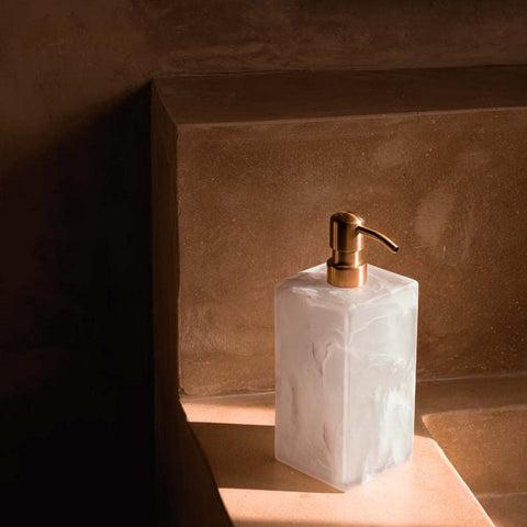 Dispenser per sapone liquido in resina marmorizzata rosa tenue e bianco 8x21 cm posizionato accanto a un lavabo in marmo