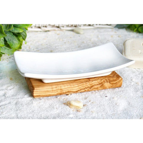 Portasapone d'arredo con ciotola in porcellana bianca sagomata posizionata su una base staccabile in legno d'ulivo sul piano di un lavabo