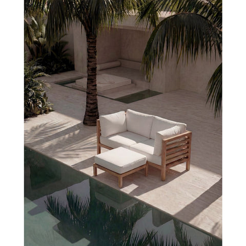 Pouf modulare da esterno con base in legno di teak e cuscino beige posizionato su una terrazza solarium d'ispirazione naturale