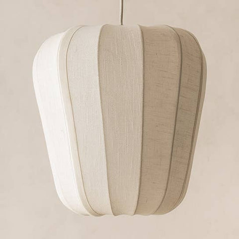 Lampada a sospensione stile Japandi Alba in cotone bianco intrecciato a forma di lanterna con luce soffusa filtrata in un interno minimalista Sumi Design.