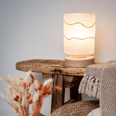 Lampada da tavolo cilindrica bianca Chrysalide in carta riciclata e base in legno stile Japandi.