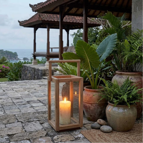  Lanterna rettangolare con maniglia superiore in teak riciclato Nusa Penida S 28x43 cm con candela accesa posizionata sotto un portico con piante