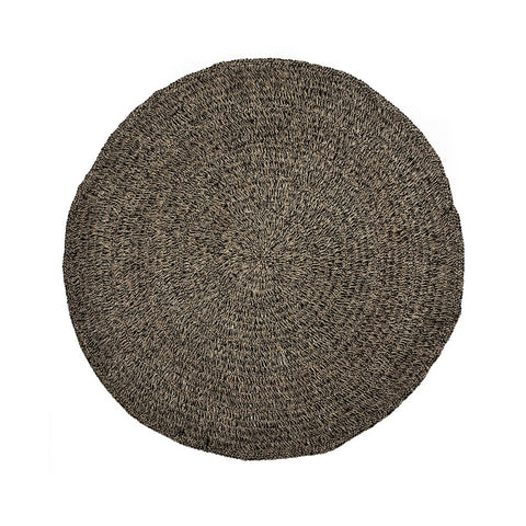 Tappeto rotondo grande in alga marina e sisal bicolore nero naturale Ø 200 cm steso a terra sotto un tavolo da pranzo rotondo in legno