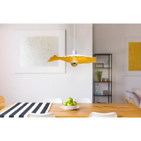 Lampada a sospensione in carta plissettata e modellabile bianca e oro Pazza di diametro 56 cm sospesa sopra un tavolo da pranzo in legno